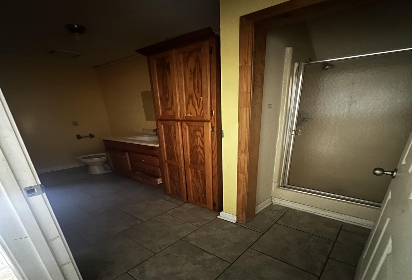 Full bathroom with a stall shower, toilet, vanity, tile patterned flooring, and baseboards