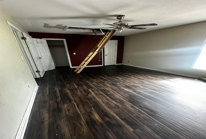 Empty room featuring ceiling fan, wood finished floors, a textured ceiling, and baseboards
