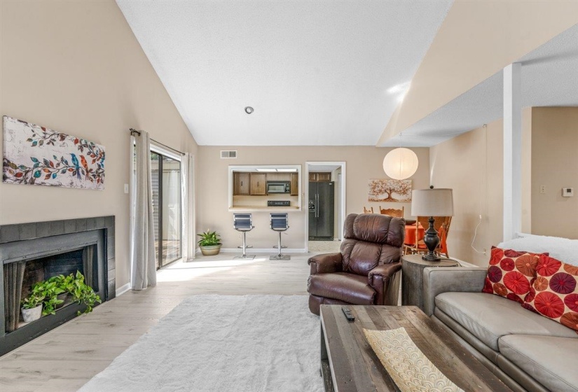 Spacious living area featuring high vaulted ceilings and light wood-finish flooring