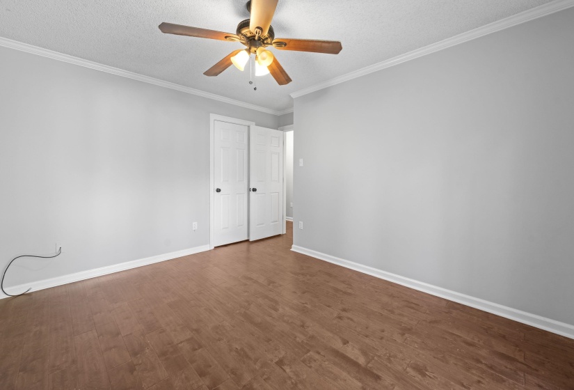Spacious room featuring wood-finish flooring, light gray walls, and white trim