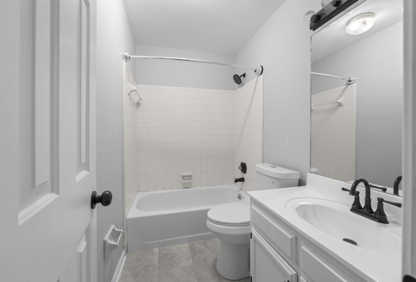 Bathroom featuring a white vanity with integrated sink, dark bronze-finish faucet, and a large wall-mounted mirror