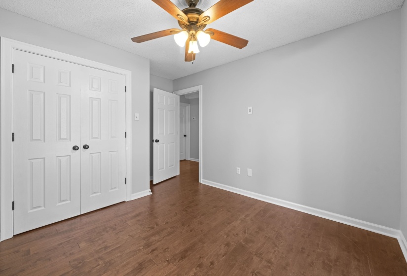 Interior room featuring wood-finish flooring, light grey walls, and white baseboards