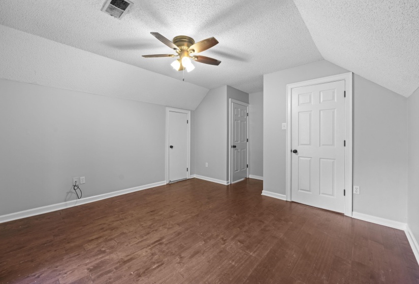 Room featuring wood-finish flooring, light gray walls, and white trim