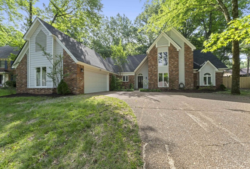 Brick and siding exterior featuring a prominent two-story window