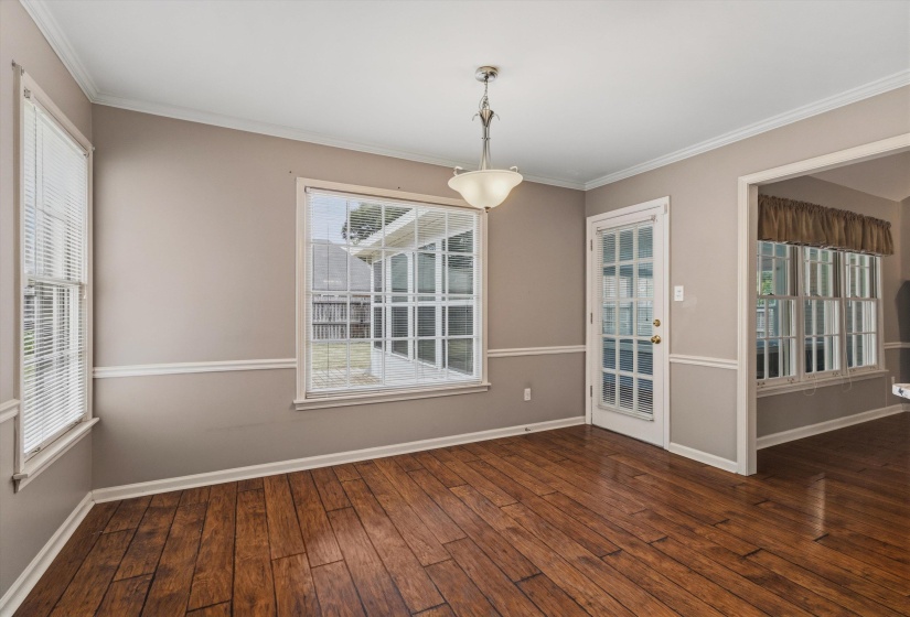 Spacious interior room featuring rich wood-finish flooring, a contemporary semi-flush mount ceiling fixture, and a glass-paneled exterior door