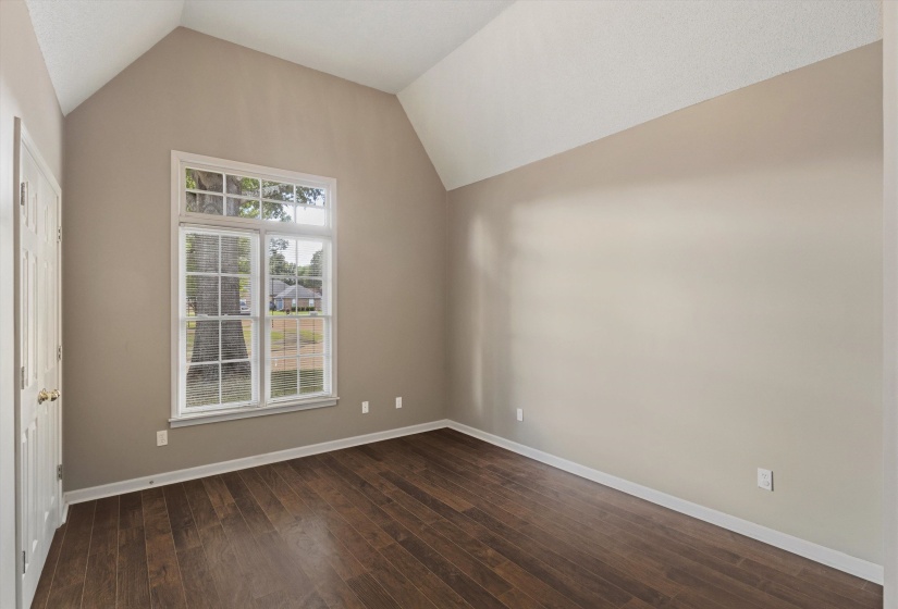 Interior room featuring a vaulted ceiling and wood-finish flooring