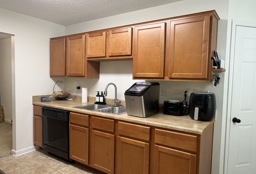 Kitchen with wood-finish cabinetry and light-toned countertops