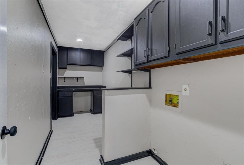 Laundry room with hookup for a washing machine, light floors, recessed lighting, a textured wall, and cabinet space