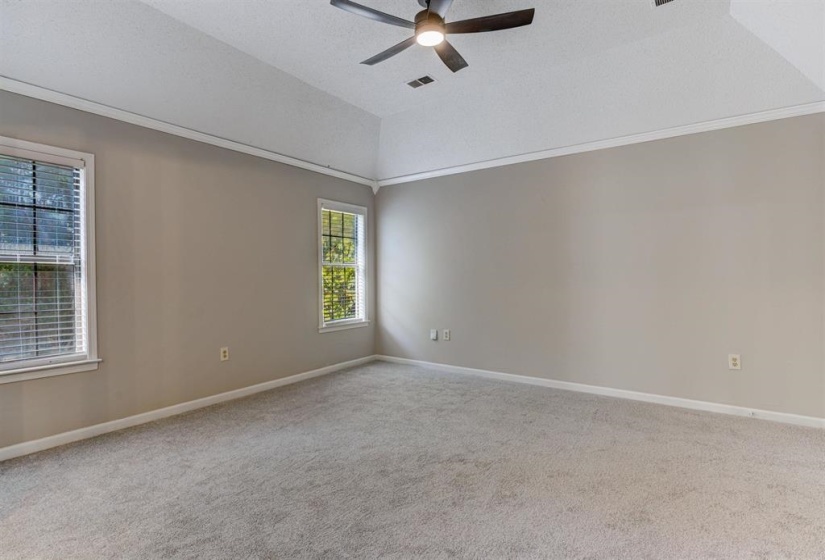 Carpeted spare room featuring a ceiling fan and baseboards