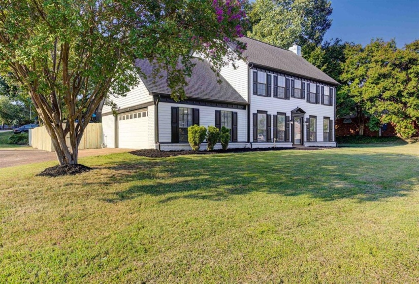 Colonial inspired home with roof with shingles, a chimney, and an attached garage