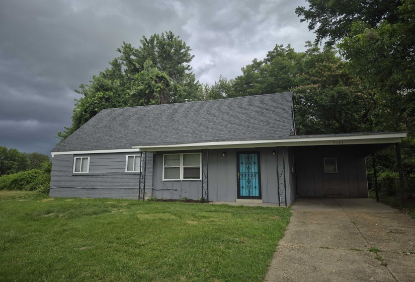 Single-story residence featuring a gray exterior, a light gray shingle roof, and a covered carport