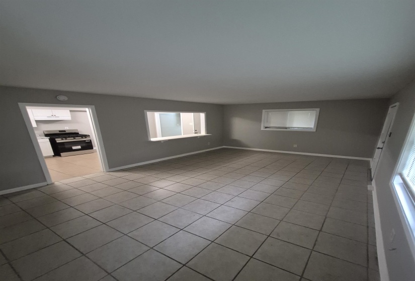 Spacious living area featuring neutral-toned tile flooring and painted walls