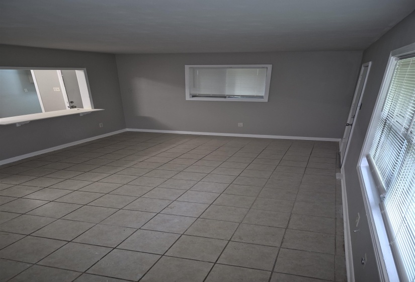 Spacious room featuring neutral grey walls and durable tile flooring throughout