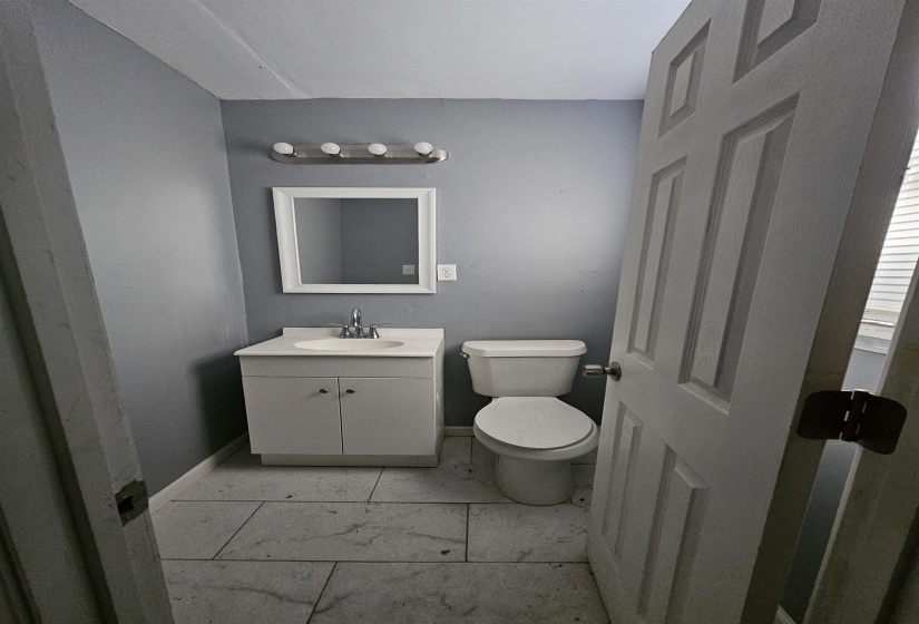 Bathroom with a white vanity, integrated sink, and chrome faucet