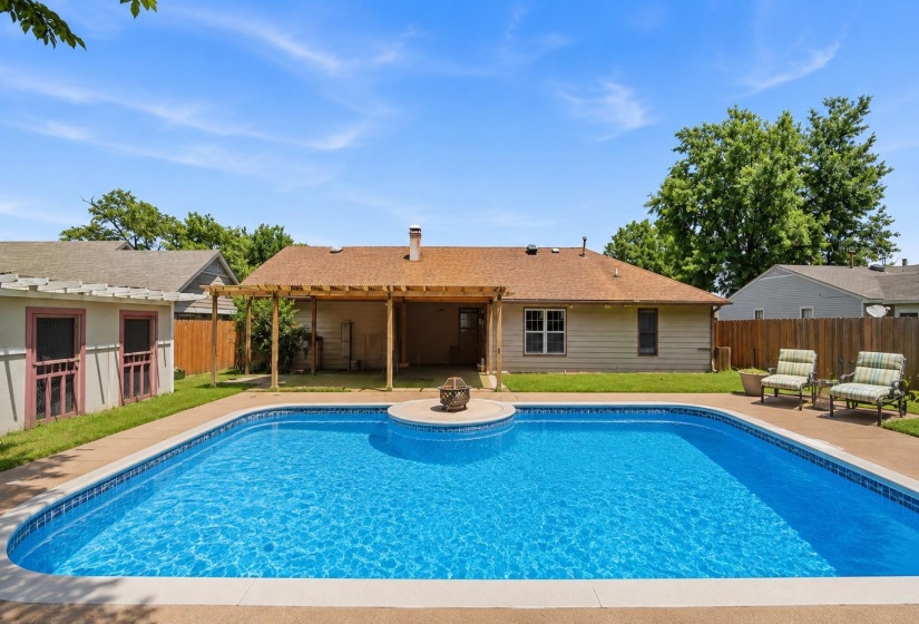 Private backyard oasis featuring an in-ground swimming pool, surrounding patio, wood pergola, and storage. Some features are AI-enhanced.
