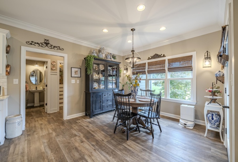 Dining area featuring wood-finish flooring, crown molding, and recessed lighting
