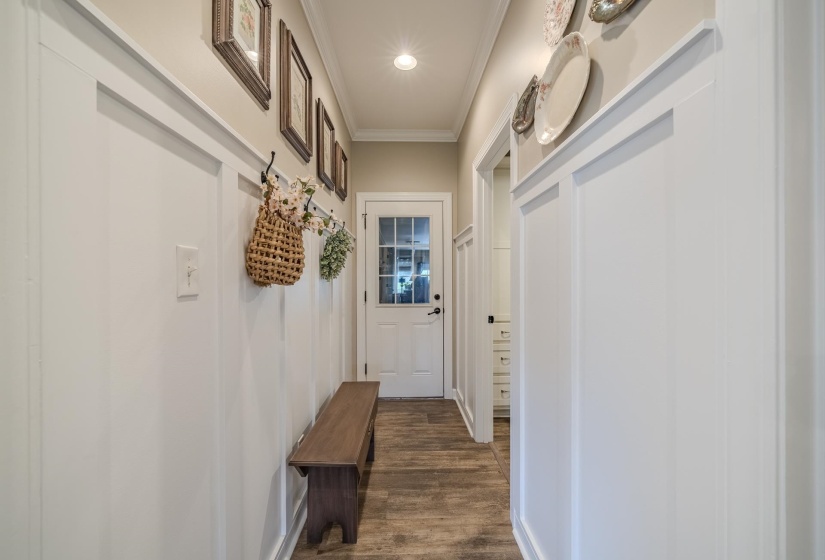 Hallway featuring white wainscoting and wood-finish flooring