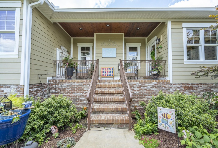 Front exterior featuring light green siding and a brick foundation