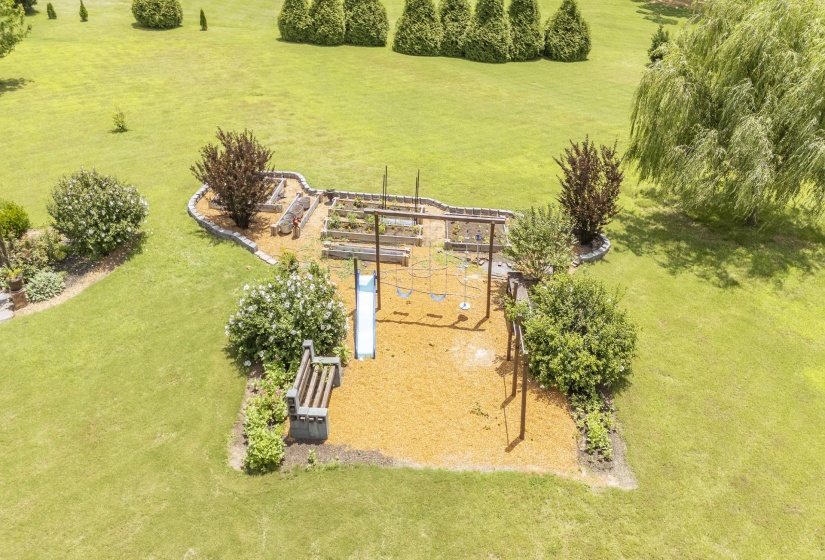 Expansive lawn with a dedicated play area featuring a slide and swings