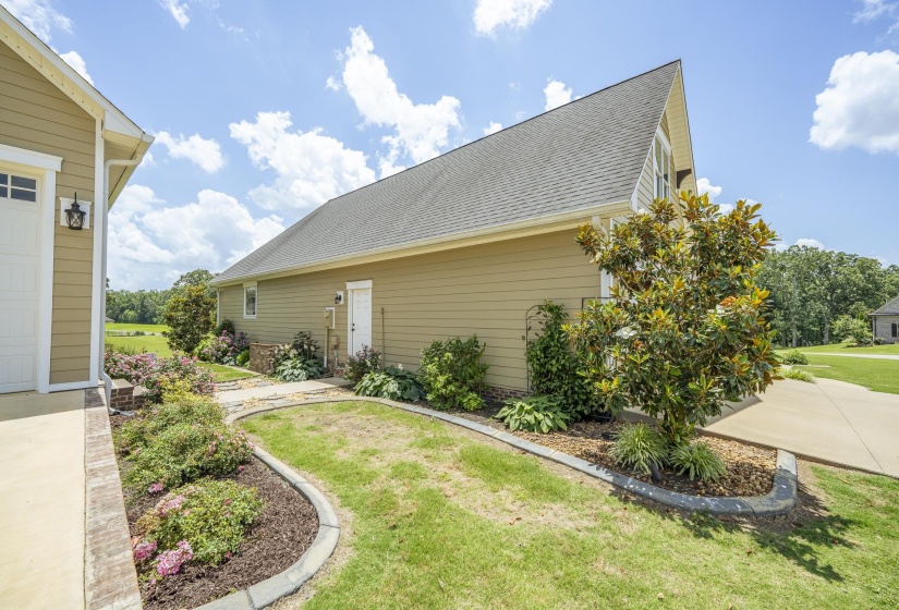 Exterior featuring tan siding, a gray shingle roof, and white trim