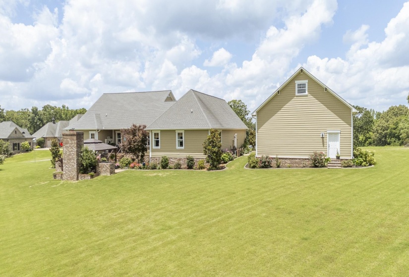 Expansive rear property featuring a detached structure with siding exterior and a separate entry door