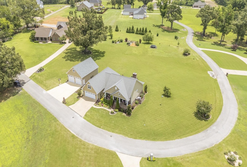 Expansive property featuring a main residence, a detached two-car garage, and a winding paved driveway
