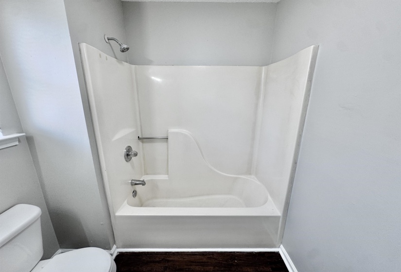 Full bath featuring shower / washtub combination and wood finished floors