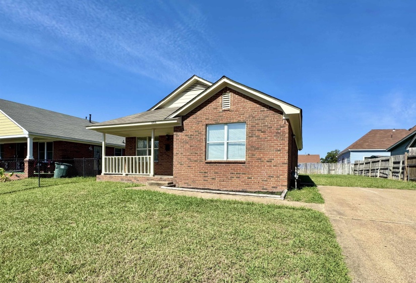 View of front facade featuring brick siding and covered porch