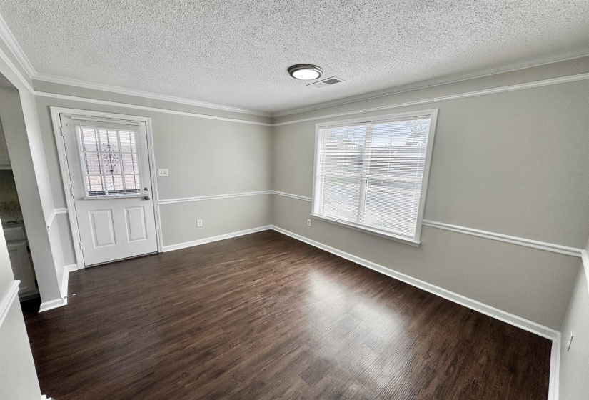 Entrance foyer with ornamental molding, dark wood-style floors, and a textured ceiling