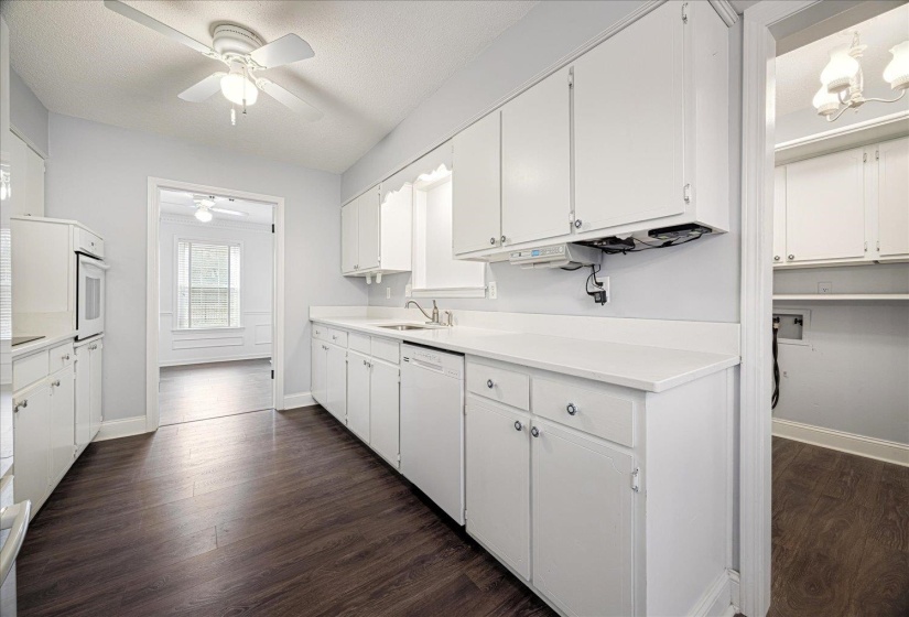 Kitchen with light countertops, white cabinetry, a textured ceiling, and dark wood finished floors