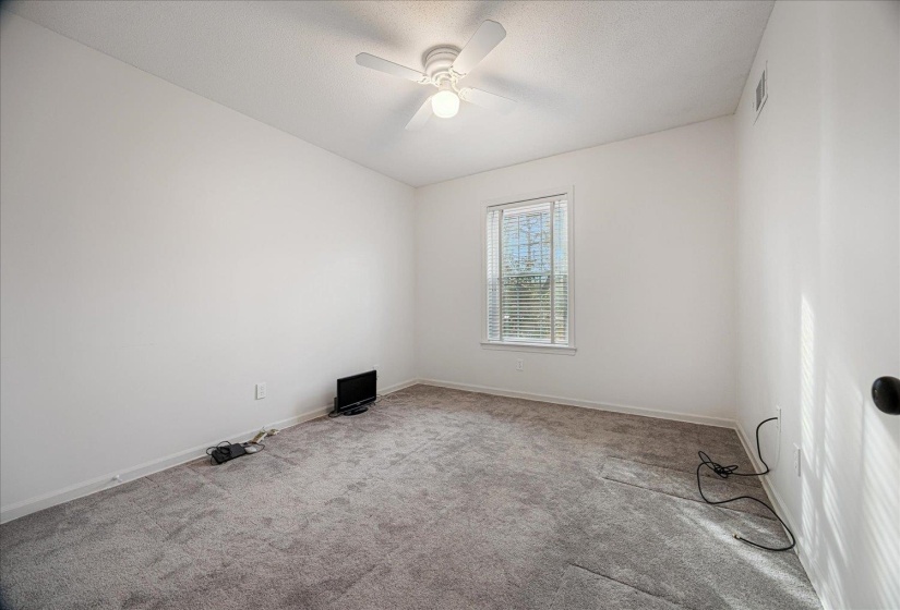 Unfurnished room featuring carpet flooring, a textured ceiling, and ceiling fan