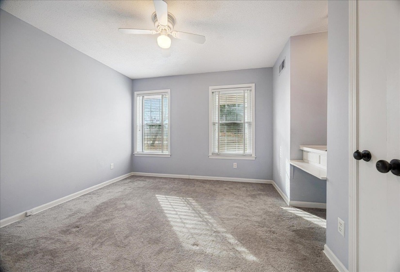 Empty room featuring carpet flooring, a textured ceiling, and a ceiling fan