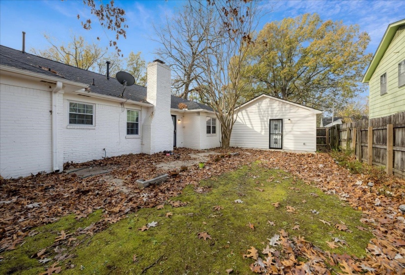 Back of house with a chimney, brick siding, and a shingled roof