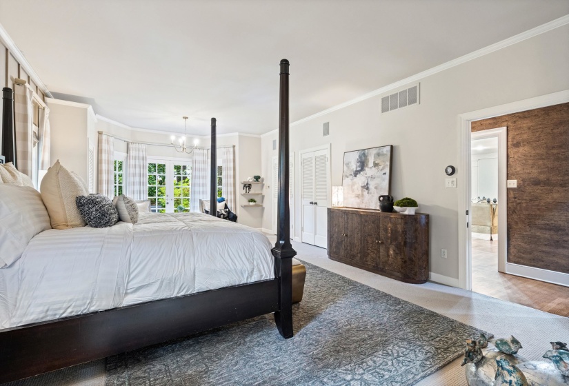 Spacious room featuring a bay window with French doors, crown molding, and recessed lighting