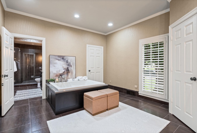 Soaking tub with dark wood-finish paneling, complemented by large format floor tiles