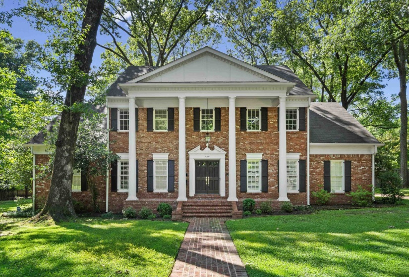 Classic brick exterior with a prominent portico featuring four substantial columns and a pediment