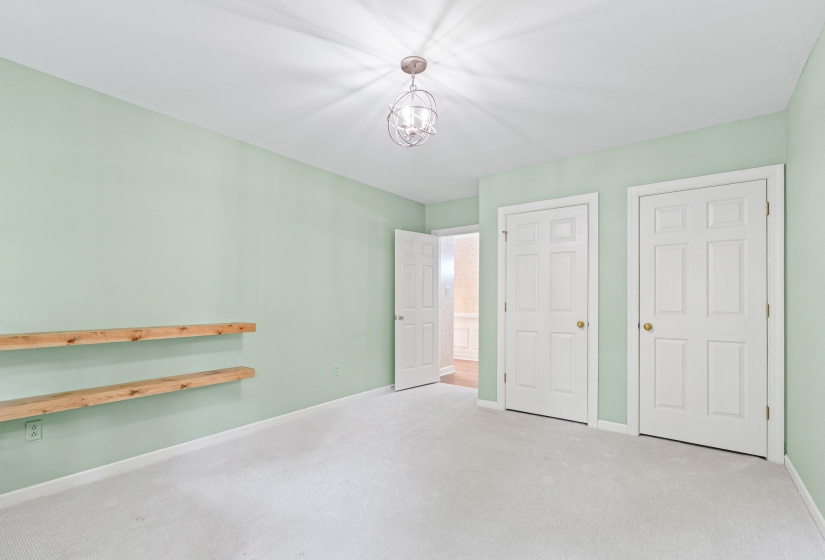 Light-filled room featuring wall-to-wall carpeting, a neutral ceiling, and light green walls