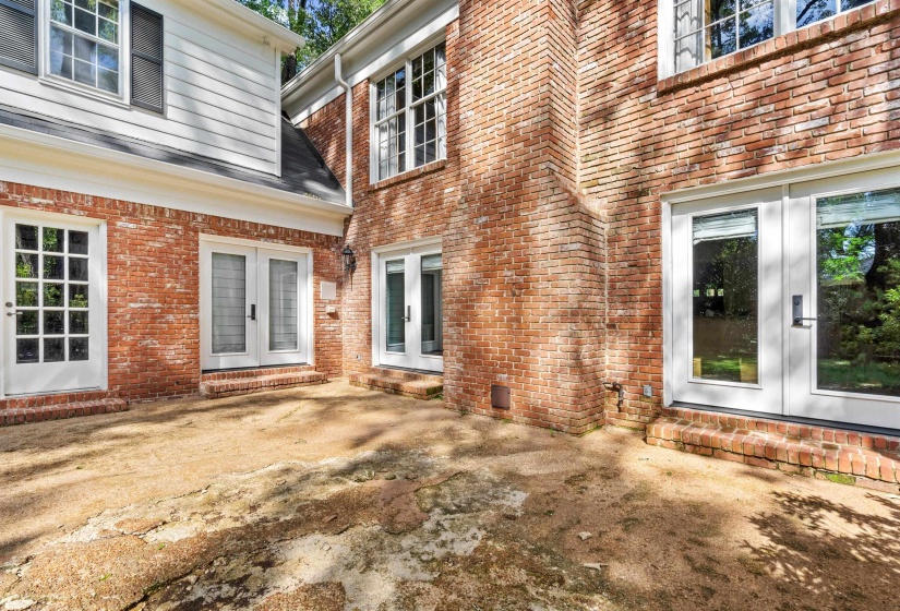 Brick exterior with multiple white-framed French doors and windows