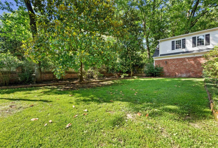 Spacious lawn area framed by mature trees and established landscaping