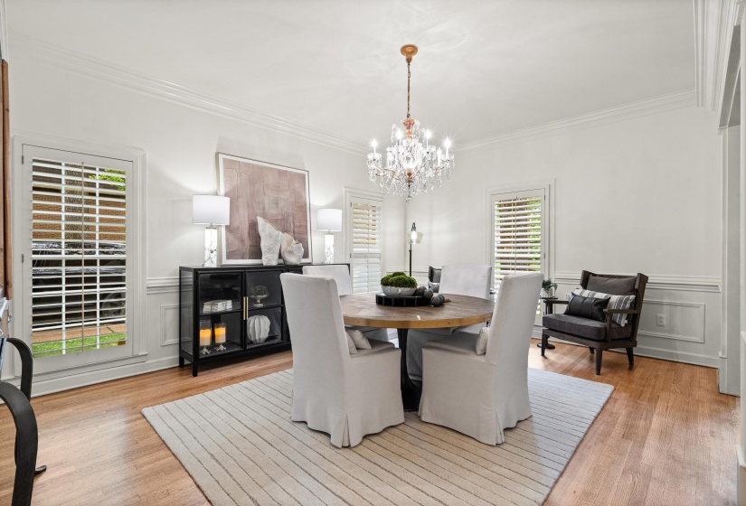Dining area with wood-finish flooring and crown molding