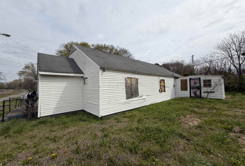 Single-story structure featuring white horizontal siding and a dark shingle roof