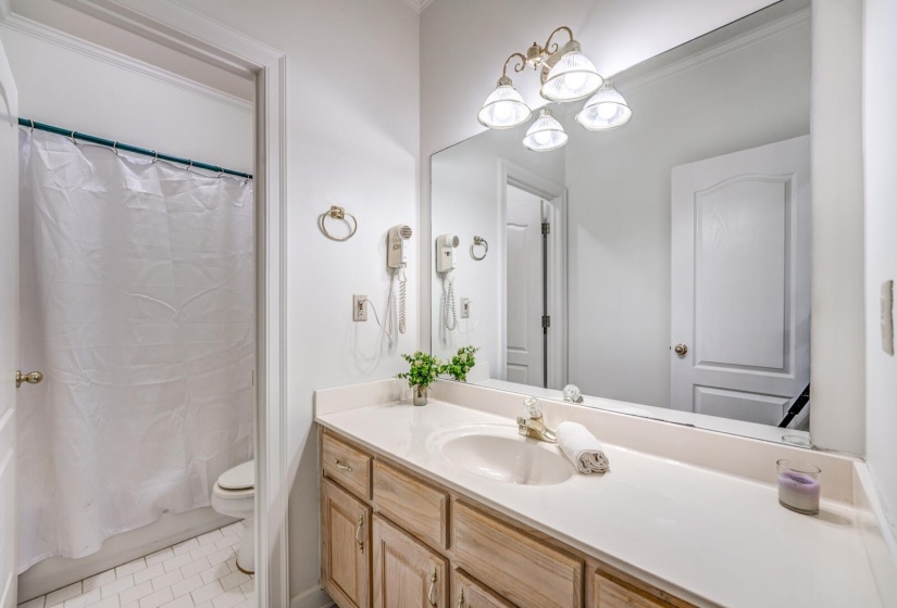 Bathroom vanity with an integrated sink, a light-toned countertop, and wood-finish cabinetry