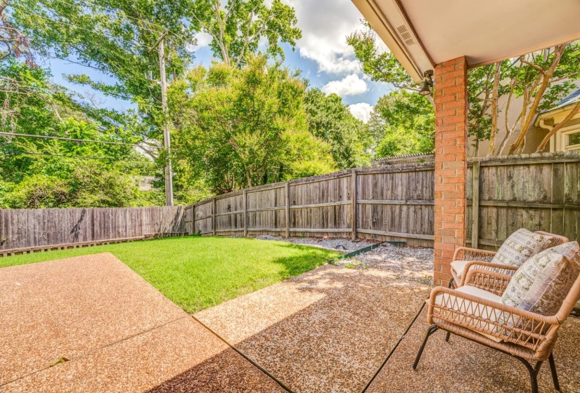 Covered patio featuring an exposed aggregate concrete surface and a brick support column