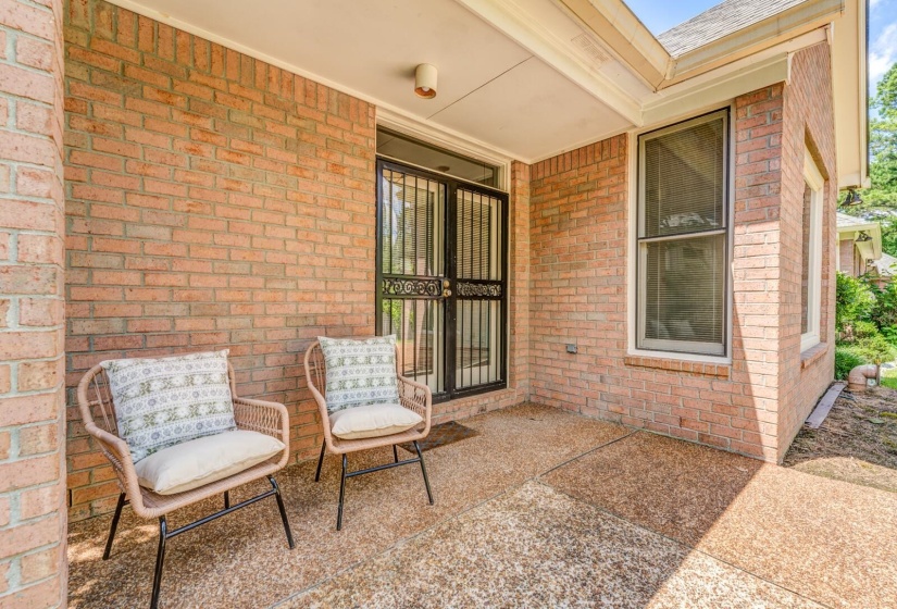 Covered patio featuring a brick exterior and exposed aggregate concrete flooring
