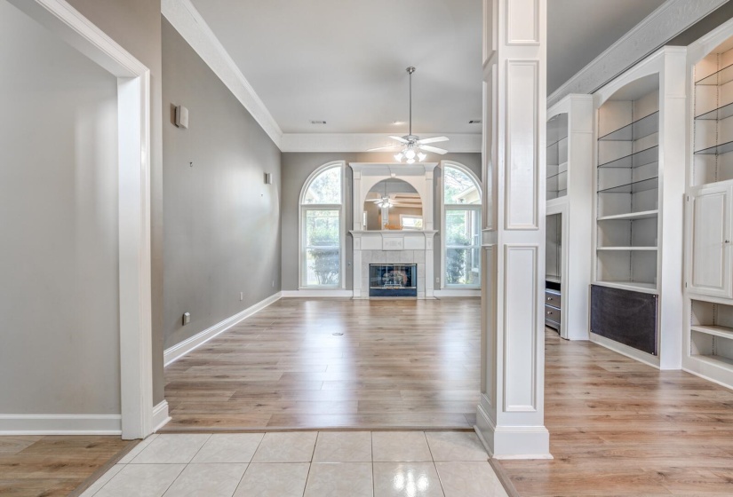 Spacious living area featuring wood-finish flooring, a fireplace with a decorative mantel, and built-in shelving