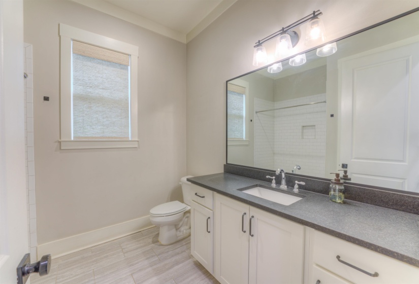 Bathroom featuring a white vanity with dark countertop, undermount sink, and black hardware