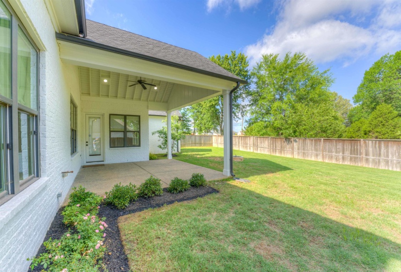 Expansive concrete patio with a covered porch, ceiling fan, and recessed lighting