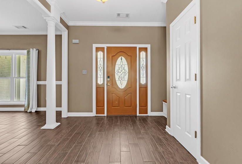 Entryway featuring a wood-finish front door with decorative glass, flanked by two sidelight windows