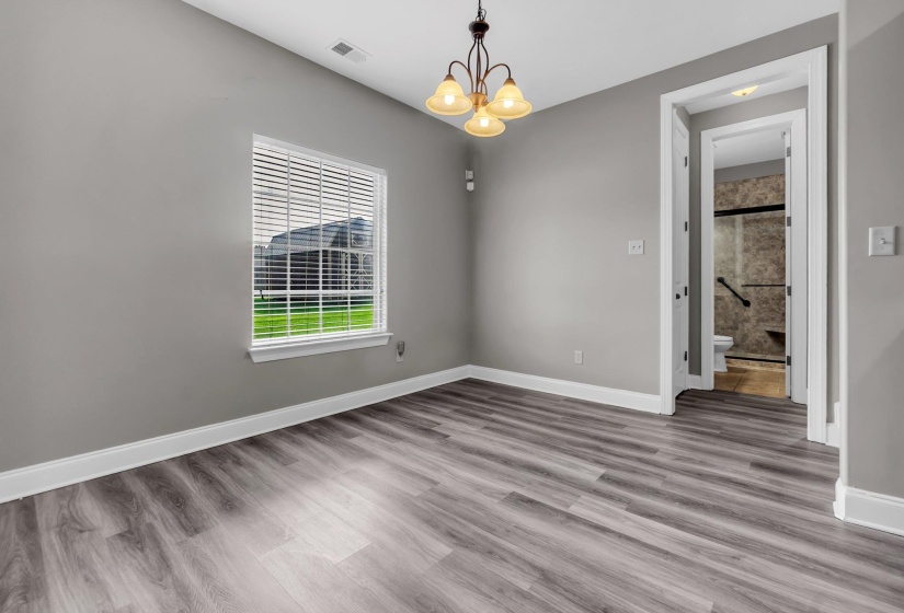 Spacious room featuring wood-finish flooring, neutral gray wall tones, and white trim