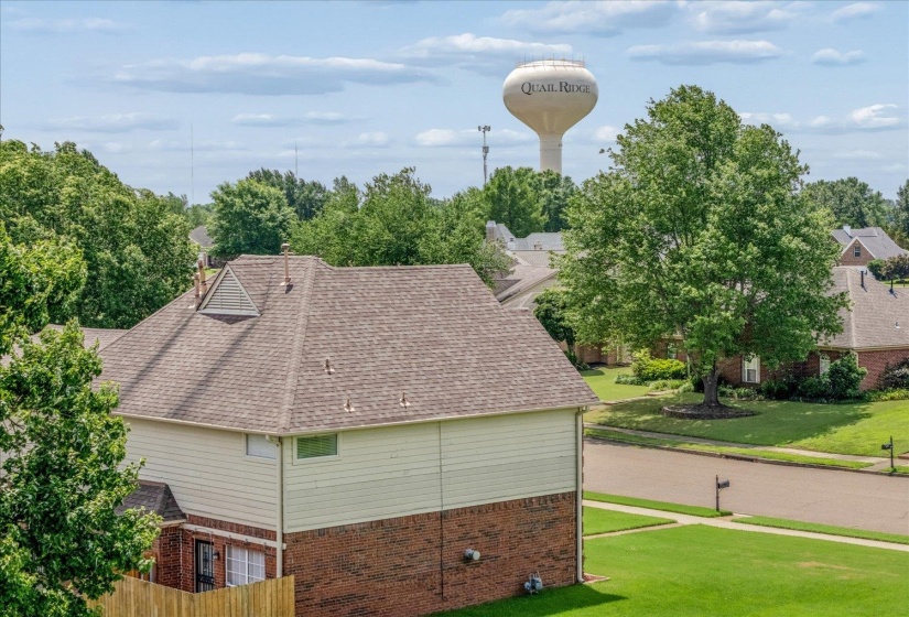 Shingle roof with a prominent dormer, wood siding, and a brick lower level.